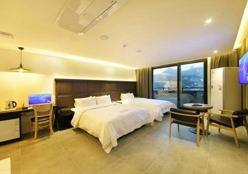 a hotel room with a large bed and a desk at Anyang Boutique Hotel AMA in Anyang