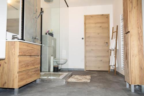 a bathroom with a sink and a toilet and a door at Loft Sous Pref in Montbéliard