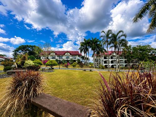 a large building with palm trees in a park at Graceland Resort Tayabas Quezon in Tayabas