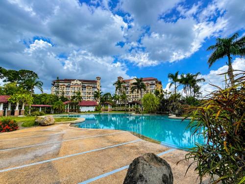 a resort swimming pool with condos in the background at Graceland Resort Tayabas Quezon in Tayabas