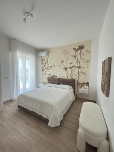 a bedroom with a large bed and a chair at Villa Ikal in Modugno