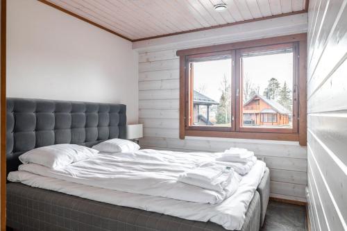 a large bed in a room with a window at Himos Mökki superior - Chalet Cottage superior ski-in-ski-out in Jämsä