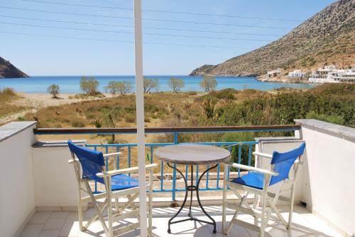 uma mesa e cadeiras numa varanda com vista para o oceano em Afroditi Hotel em Kamari