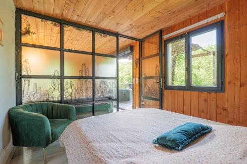 a bedroom with a bed and a chair and windows at Casa Frida in Salavas