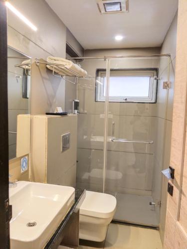 a bathroom with a shower and a toilet and a sink at CENTRAL A BOUTIQUE HOTEL in Belgaum