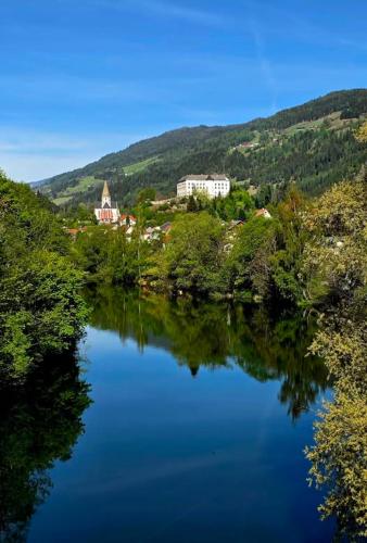 a view of a river with a town in the background at Chalet "Knusperhäuschen" in Murau