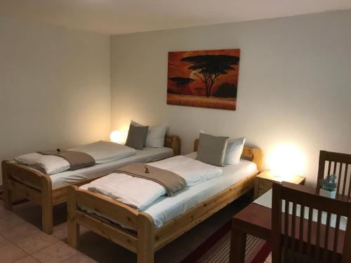 two twin beds in a room with a painting on the wall at Villa Schaumburg - Boutique Hotel in Rinteln