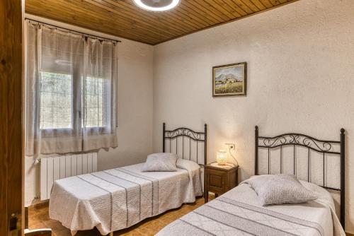 a bedroom with two beds and a window at Mas Pareta - La Figuera in Fonolleras