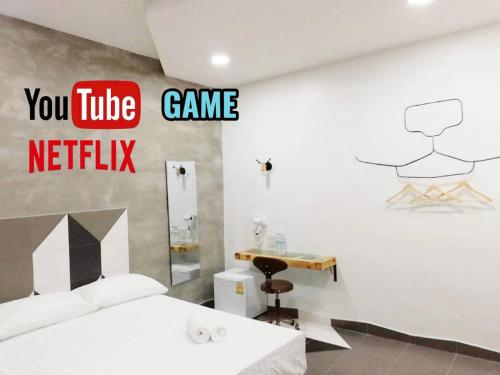 a bedroom with a bed and a video game netflix sign at Hoft Hotel Ramkhamhaeng24 in Sathani Khlong Tan