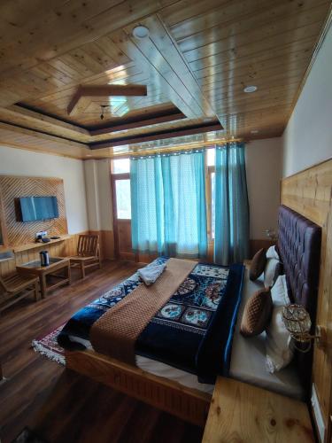 a bedroom with a large bed with blue curtains at The sky walk in Manāli