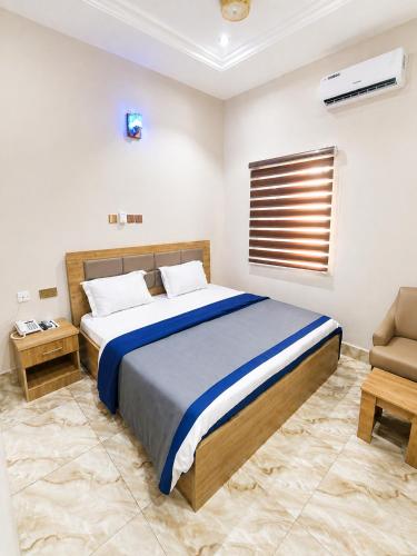 a bedroom with a large bed and a chair at The Whale Inn Narayi rd Barnawa high cost in Kaduna