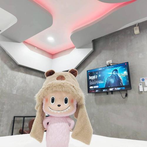 a stuffed animal in a room with a tv at Hoft Hotel Ramkhamhaeng24 in Sathani Khlong Tan