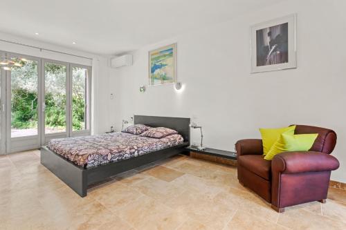 a bedroom with a bed and a chair at Chambres D’hôte Cotignac in Cotignac