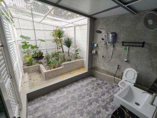 a bathroom with a shower and a toilet and a sink at 19 Farmstay in Bukit Mertajam