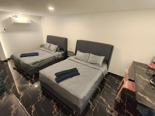 a room with two beds and a chair in it at 19 Farmstay in Bukit Mertajam
