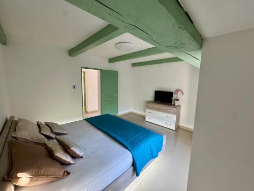 a bedroom with a bed with blue sheets and a television at Maison en campagne in Salon-de-Provence