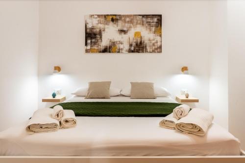 a white bedroom with a bed with towels on it at Il Cortile Holiday House in Caccamo