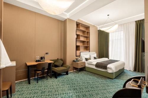 a hotel room with a bed and a desk at NOOMA Hotel Aitmatova in Bishkek