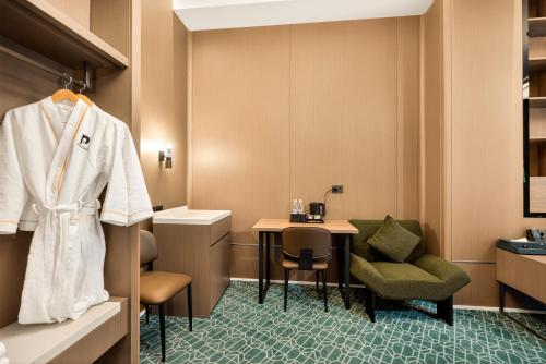 a room with a table and a white jacket hanging on a wall at NOOMA Hotel Aitmatova in Bishkek