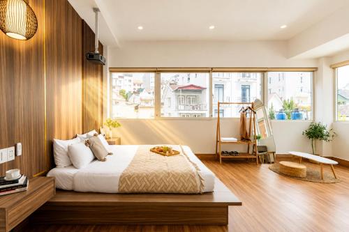 a bedroom with a bed and a large window at The Morris Central Hotel - O'TEL in Da Lat