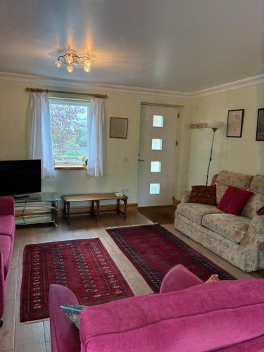 a living room with a couch and a tv at Maple House Apartment in Kelso