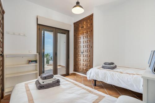 a bedroom with two beds and a sliding glass door at Villa Quietud in Salobreña