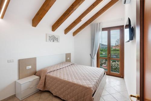 a bedroom with a bed and a window at Villa Degli Dei in Agerola