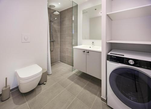 a bathroom with a washing machine and a toilet at World Trade Center Ballerup - Forenom in Ballerup