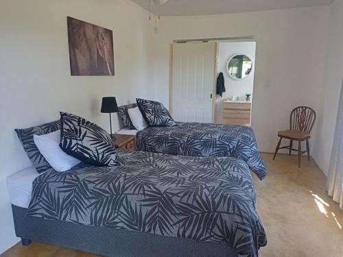 a bedroom with two beds and a bed and a chair at Zebra game farm in Brits