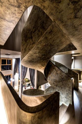 a staircase in a living room with a stone wall at Hotel Valentinerhof in Siusi