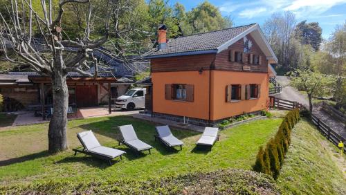 a house with a group of chairs and a house at Chalet & SPA Privata - Baita al Frassino, Ospitar in Vignola