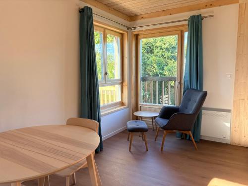 a room with a table and chairs and windows at Les Gîtes du Chênelet in Landrethun-le-Nord
