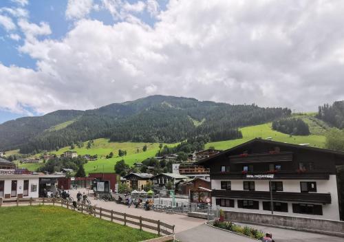 a town in the mountains with a green hill at Hotel Pinzgauerhof - Inclusive Evening Dinner in Saalbach-Hinterglemm
