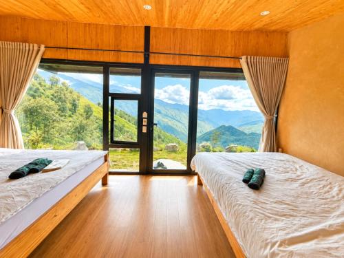 two beds in a room with a view of mountains at Samu Retreat Tà Xùa in Bắc Yên