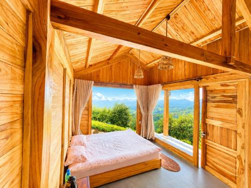 a bedroom with a bed and a large window at Samu Retreat Tà Xùa in Bắc Yên