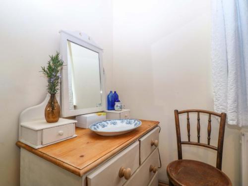 a mirror on top of a dresser with a sink at Pen Glorian in Conwy