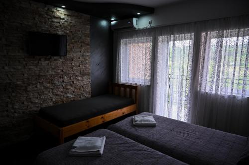 a bedroom with two beds and a tv and a window at RA Apartmani Vrdnik in Vrdnik