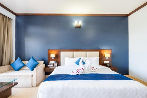 a blue bedroom with a bed and a couch at Revathi Resorts in Jajal