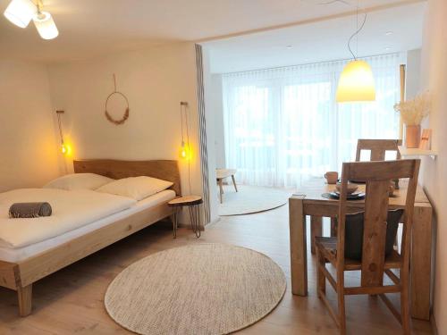 a bedroom with a bed and a table and a desk at Dahoam beim Haas in Rieden