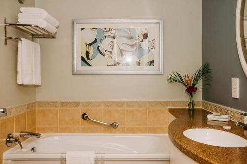 a bathroom with a bath tub and a sink at Southern Sun Dar es Salaam in Dar es Salaam