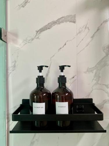 two bottles of alcohol on a shelf in a bathroom at The Town Pool Villas in Krabi