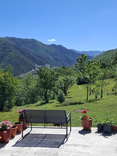 a bench sitting in front of a field with plants at Villa Lugina in Fushë-Buall