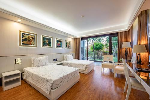 a bedroom with two beds and a desk at Carmelina Beach Resort Ho Tram in Ho Tram