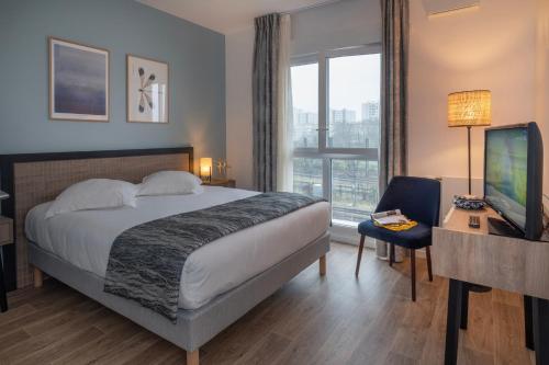 a hotel room with a bed and a desk and a television at DOMITYS - Les Canotiers in Argenteuil
