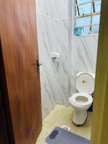 a bathroom with a toilet and a wooden door at ONE BEDROOM THIKA ROAD ,TRM DRIVE Homes by Essyruby in Nairobi
