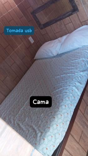 a bed with a sign that says canama on it at Suite Love in Paty do Alferes