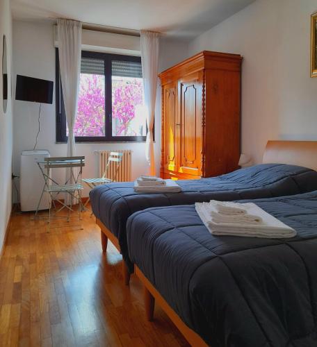 a bedroom with two beds and a window at Aromatika, b&b, affittacamere in Faenza