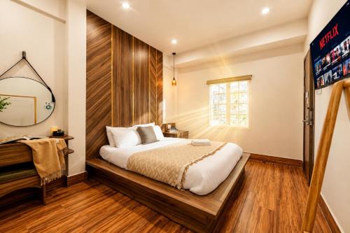 a bedroom with a bed and a mirror at The Morris Central Hotel - O'TEL in Da Lat