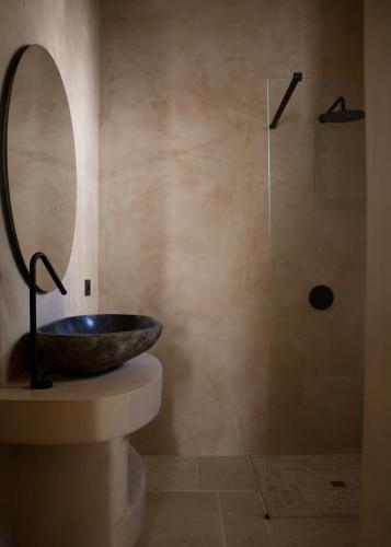 a bathroom with a stone sink and a shower at Casa Olivi in Ventotene