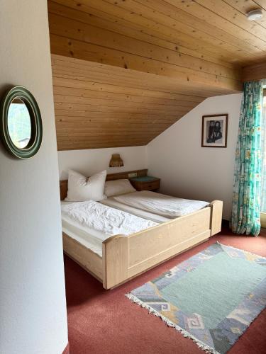 a bed in a room with a wooden ceiling at Gästehaus Valentina in Mayrhofen